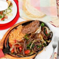 Fajitas Al Carbon · Sliced skirt steak grilled with onions, tomatoes, green peppers, and poblano peppers.