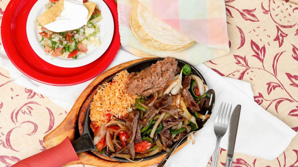 Fajitas Al Carbon · Sliced skirt steak grilled with onions, tomatoes, green peppers, and poblano peppers.