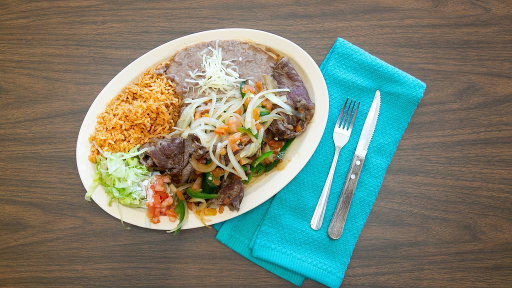 Bistec A La Mexicana · Steak topped with grilled onions, tomatoes, and pepper. Served with rice and beans.