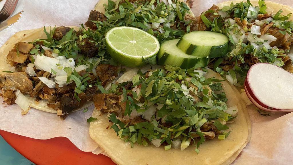 Tacos Tradicionales · Your choice of meat, double soft corn tortillas topped with onions and cilantro.