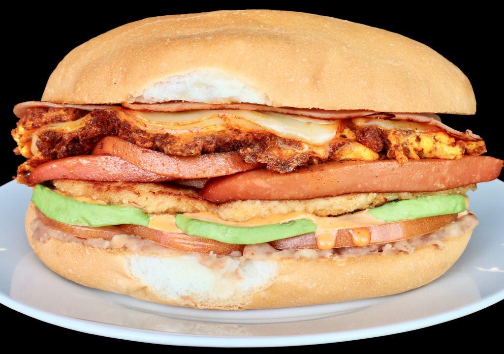 Cubana Pollo · Chicken Milanesa, Hot dogs, Ham, Egg, Chorizo, Refried Beans, Avocado, Queso, Jalapeños, Onions, Mayo, Lettuce, Tomatoes & Chipotle sauce. One Bag of Potato Chips on the Side.