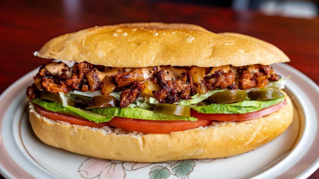 Torta Al Pastor · Marinated Pork, Cooked with Pineapple, Refried Beans, Cheese, Avocado, Jalapeños, lettuce, tomatoes and ChipotleMayo. One bag of Potatoes Chips on the side.