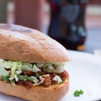 Torta · A Mexican sandwich that includes beans, lettuce, tomato, sour cream, cheese and your choice ...