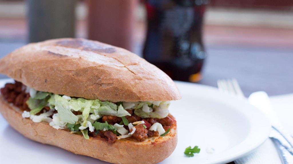 Torta · A Mexican sandwich that includes beans, lettuce, tomato, sour cream, cheese and your choice of meat.