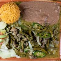 Guisado De Puerco · Puerco chunks of pork marinated in green tomatillo salsa with cactus strips.