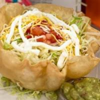 Taco Salad · Crispy, edible tortilla bowl topped with tomato, lettuce, cheese, sour cream, guacamole, and...