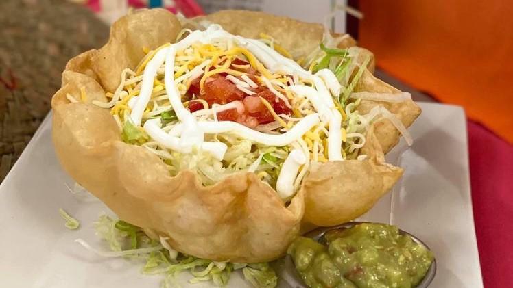 Taco Salad · Crispy, edible tortilla bowl topped with tomato, lettuce, cheese, sour cream, guacamole, and cheese dip. Choice of beef or chicken.