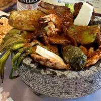 Molcajete · Pork, chorizo, steak, chicken and shrimp served in a stone bowl. Served with cactus, potatoe...