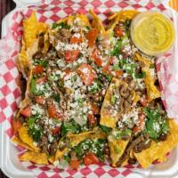 Nachos · Chips covered in beans, white melted cheese, any meat of your choice, cilantro, onions, toma...