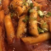 Dukbokki · Stir fried spicy rice cake topped with green onion and sesame seeds.