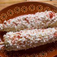 Elote · Mexican sweet corn. Comes with mayo, Mexican cheese, chili powder and a lime wedge.