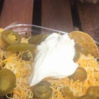 Chicken Nachos · Grilled chicken smothered in a nacho cheese sauce with jalapeños, salsa and sour cream on top.