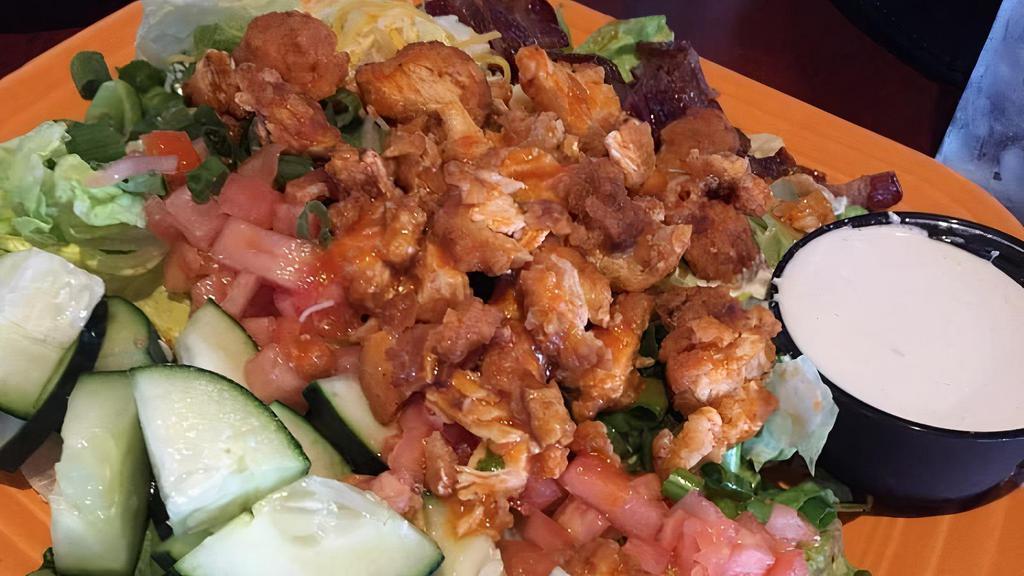 Buttermilk Fried Chicken Salad · Buttermilk fried chicken with chopped romaine and fresh greens with roasted corn, shredded carrots, cheddar and jack cheeses, crumbled bacon, diced eggs, and roasted tomatoes served with buttermilk ranch dressing.