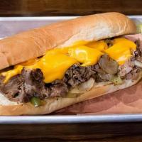 Philly Cheesesteak Sandwich · Made with thinly sliced rib eye steak, sauteed onions, peppers, and cheddar cheese sauce ser...