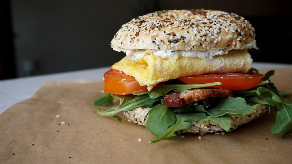 Bakehouse Belt · What’s better than a classic BLT you ask? Add Egg of course! Classic BLT with thick cut bacon  juicy tomatoes, fresh cooked egg and peppery arugula topped with scallion cream cheese and your choice of bagel!