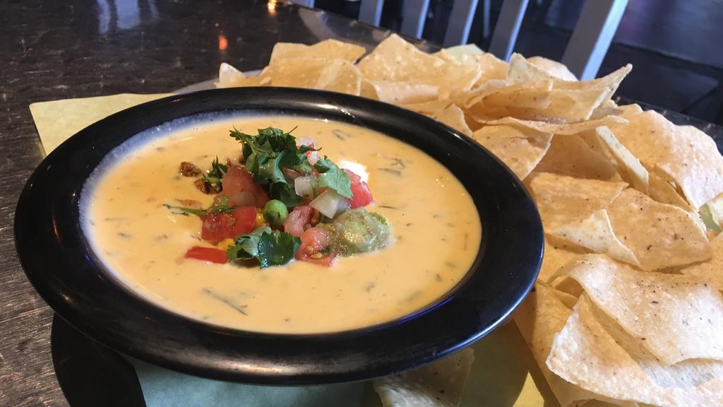 Wicked Queso · Melted green chile queso topped with chorizo, guacamole, sour cream, corn pico, and cilantro, served with tortilla chips. Add 6 pc of flour tortillas for an additional charge.