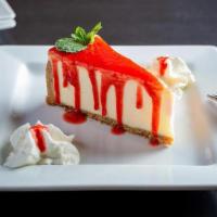 Cheesecake · Creamy cheesecake with graham cracker crust and strawberry sauce