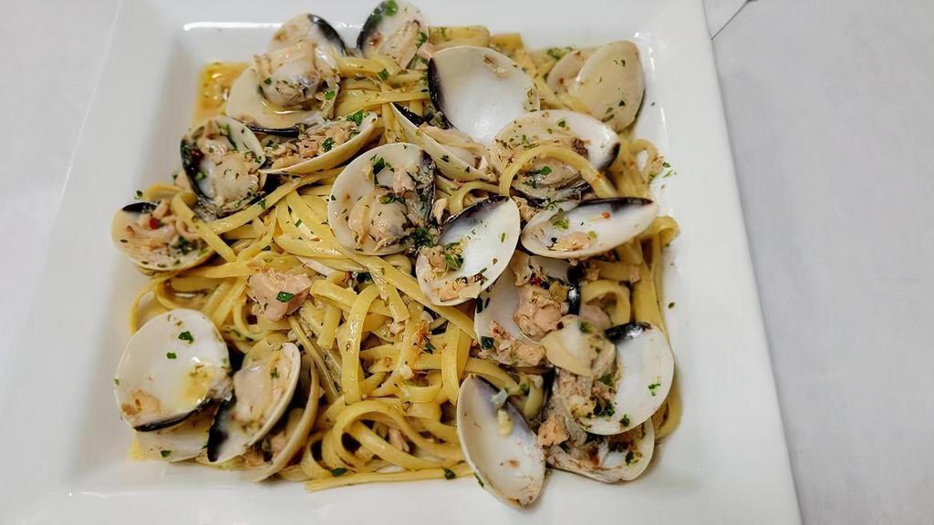 Linguine Alle Vongole · Linguine pasta cooked with premium wild caught clams, white wine, olive oil, oregano and red pepper. Prepared with garlic and topped with shredded Parmesan cheese.