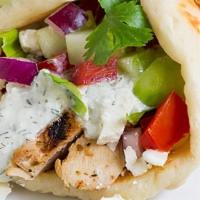 Chicken Gyro Sandwich · Marinated chicken, lettuce, tomato, and onion dressed with tahini or cucumber sauce on pita ...