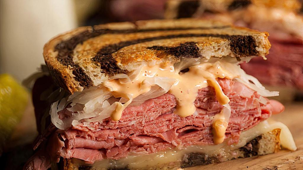 The Reuben · Our reuben starts with sautéed onions and garlic, corned beef, sauerkraut, the king's white wine 1000 island, and Swiss cheese (wrapped in foil as a courtesy) - as a courtesy, we place the toasted thick rye on the side with small fry.