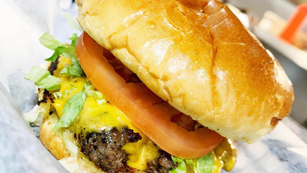 Cheeseburger · Burger, American cheese, lettuce, tomato, pickle and onion on a toasted brioche bun.