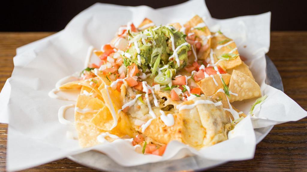 Nachos · Fresh tortilla chips, refried beans, melted chihuahua topped with guacamole, jalapenos, pico de gallo, sour cream