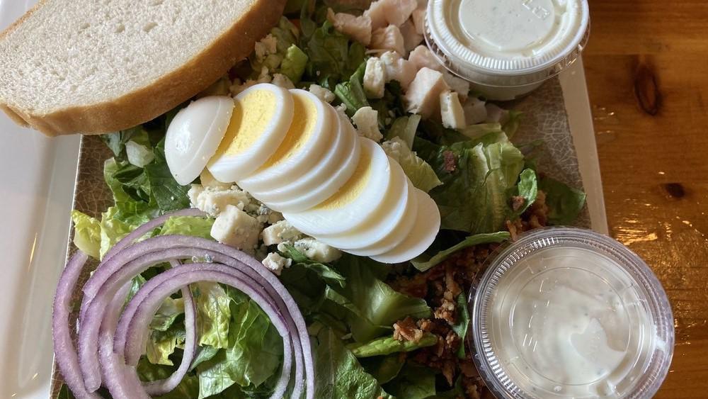 Cobb Salad · Romaine, oven-roasted turkey, Roma tomatoes, red onions, bacon, hard-boiled egg, crumbled bleu cheese, and Hidden Valley Ranch dressing.