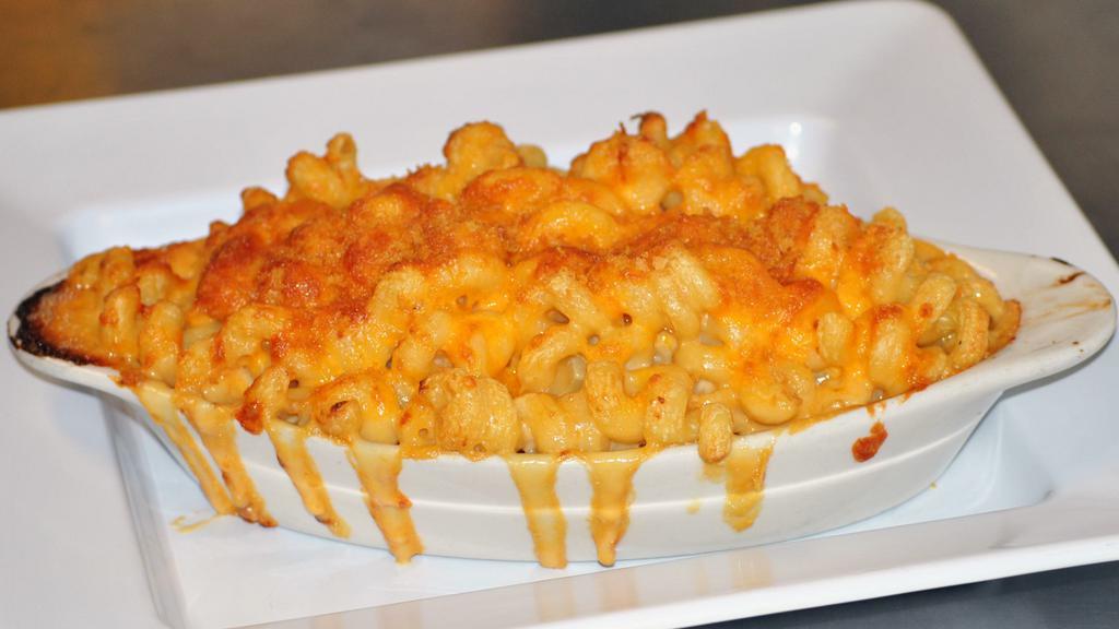 Baked Mac 'N' Cheese · Lightly baked extra-large portion of macaroni with house-made Wisconsin cheddar cheese sauce, topped with panko bread crumbs and grated cheddar cheese. Add jalapeños, hot pepper mix, or diced peppadew peppers, And/or diced ham, chicken, bacon, or chili for an additional charge.