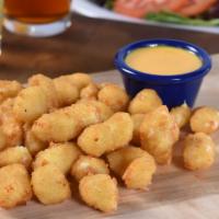 Cheese Curds · A basket full of lightly battered curds of cheese, deep-fried golden brown and served with d...