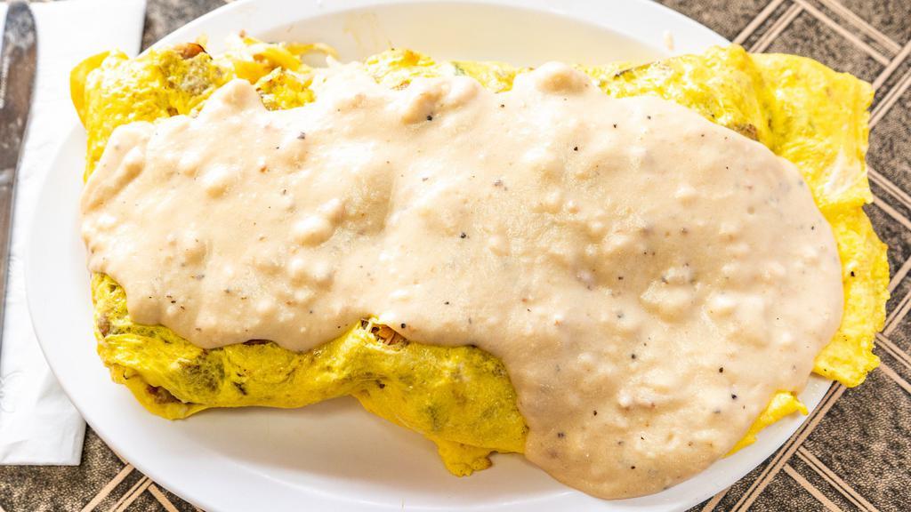 Country Omelette · Sausage, green peppers, onions, American cheese, with hash browns inside and smothered with sausage gravy.