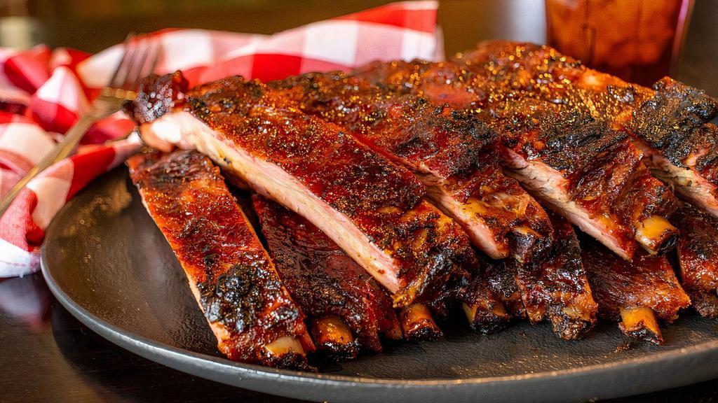 Slab Ribs · A full slab of our honey rubbed pork spare ribs slow smoked over hickory wood and cut to order. Mmmmm Boy!