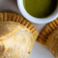 Samosa · Homemade triangular pastries made of white flour stuffed with seasoned and peas served with ...