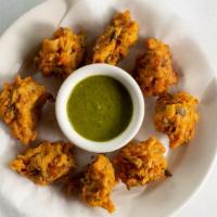 Fresh Vegetable Pakoras · Made of mixed vegetables battered in graham flour and ground beans fried and served with cor...