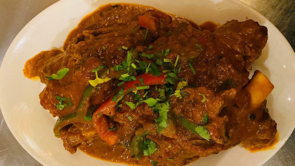 Roasted Lamb Shank · A big piece of lamb shank marinated then slow-roasted in a thick curry sauce, topped with red and green peppers  served with basmati rice.