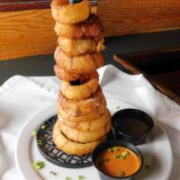 Onion Rings Tower · A stack of crispy, breaded and fried rings served with tangy BBQ sauce.