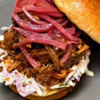 Carolina Style Pulled Pork Sandwich · Beeler’s bone-in pork shoulder is marinated in our Smokeheads Signature Dry Rub and steadily...