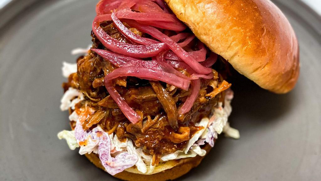 Carolina Style Pulled Pork Sandwich · Beeler’s bone-in pork shoulder is marinated in our Smokeheads Signature Dry Rub and steadily smoked until beautifully caramelized, smoky and fork tender. We build each sandwich in true Carolina-style by loading a potato bun high with fork-pulled pork and topping it with sliced pickles, fresh coleslaw and pickled red onions. This sandwich goes perfect with our Smokeheads Mac & Cheese.