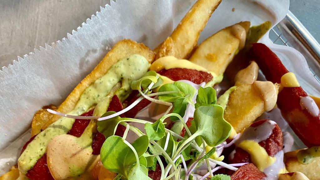 Salchipapas · Gluten-free. Peruvian fries,  sliced beef hot dog with yellow pepper, black olive, cilantro, and spicy rocoto sauces.
