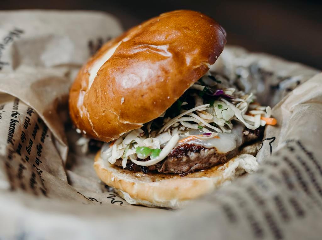 Korean Short Rib Burger · Korean short rib burger with Asian slaw & Munster cheese.