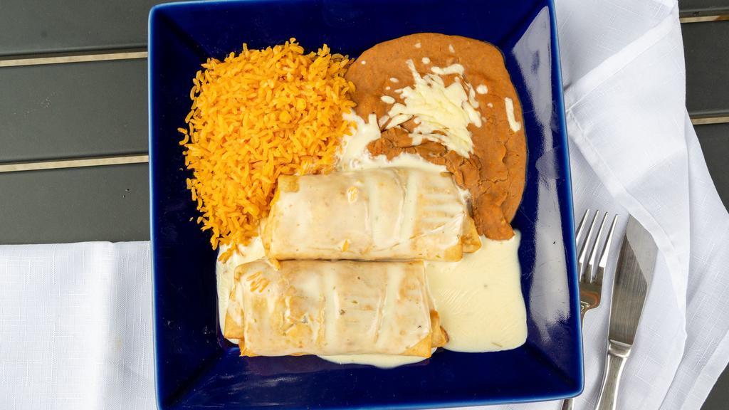 Chimichangas · Filled with peppers, topped with cheese dip, mushrooms, onions, and tomatoes. Served with rice and beans.
