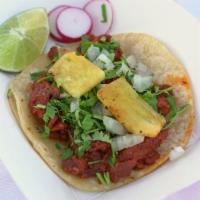 Tacos Al Pastor · Marinated pork served on a corn tortilla with pinneapples