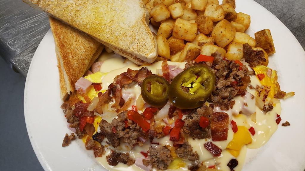 The Works Omelet · GIGANTIC 4 egg omelet loaded with everything but the kitchen sink. Ham, bacon and sausage, hash browns, bell pepper, onions, jalapeños, tomatoes, and melted cheddar jack cheese. Then smothered in Queso cheese. Served with potato and toast.