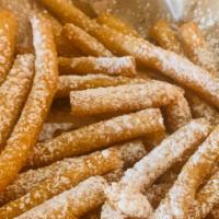Funnel Cake Fries · Sticks of funnel cake with powdered sugar on top.