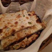 Cheese Naan · A white flour bread inside with homemade cottage cheese and baked fresh in our tandoor.