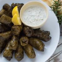 Dolmades · Grape leaves stuffed with ground lamb and beef with rice , and Greek spices , served with Tz...