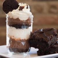 Brownie Parfait · A MASON JAR DESSERT MADE FROM OUR FUDGE BROWNIES LAYERED BETWEEN CHOCOLATE PUDDING AND WHIPP...