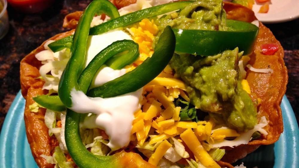 Taco Salad · Crisp flour tortilla shell filled with lettuce, tomatoes, bell pepper, cheese, green onions guacamole, & sour cream