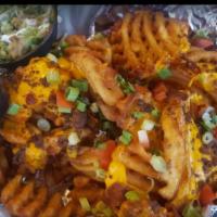 Nacho Fries · A mound of waffle fries topped with melted cheese, tomatoes, bacon, green onion and ground b...