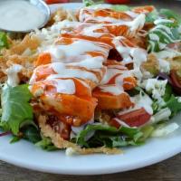 Spicy Buffalo Chicken Salad · Crisp greens tossed with celery, red onions, bleu cheese and tomatoes in a ranch dressing, t...