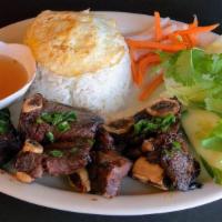 Com Suon Dai Han · Rice with Beef Short Ribs & Egg. Served with fresh lettuce, cucumber, and pickled carrots & ...